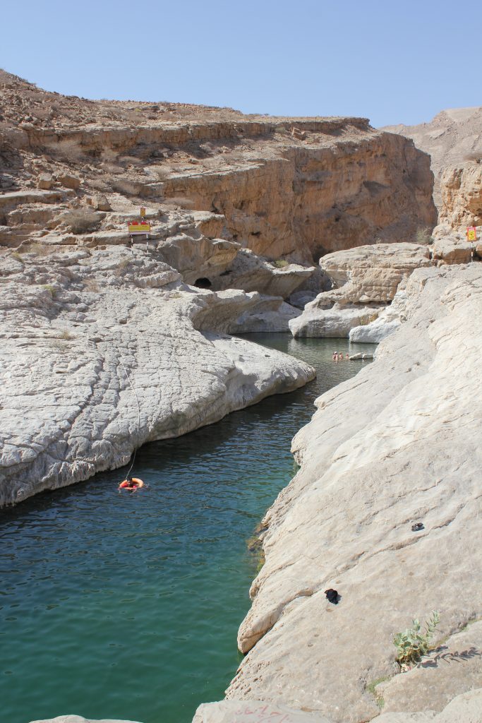 The gorges with green colored water in Wadi Bani Khalid